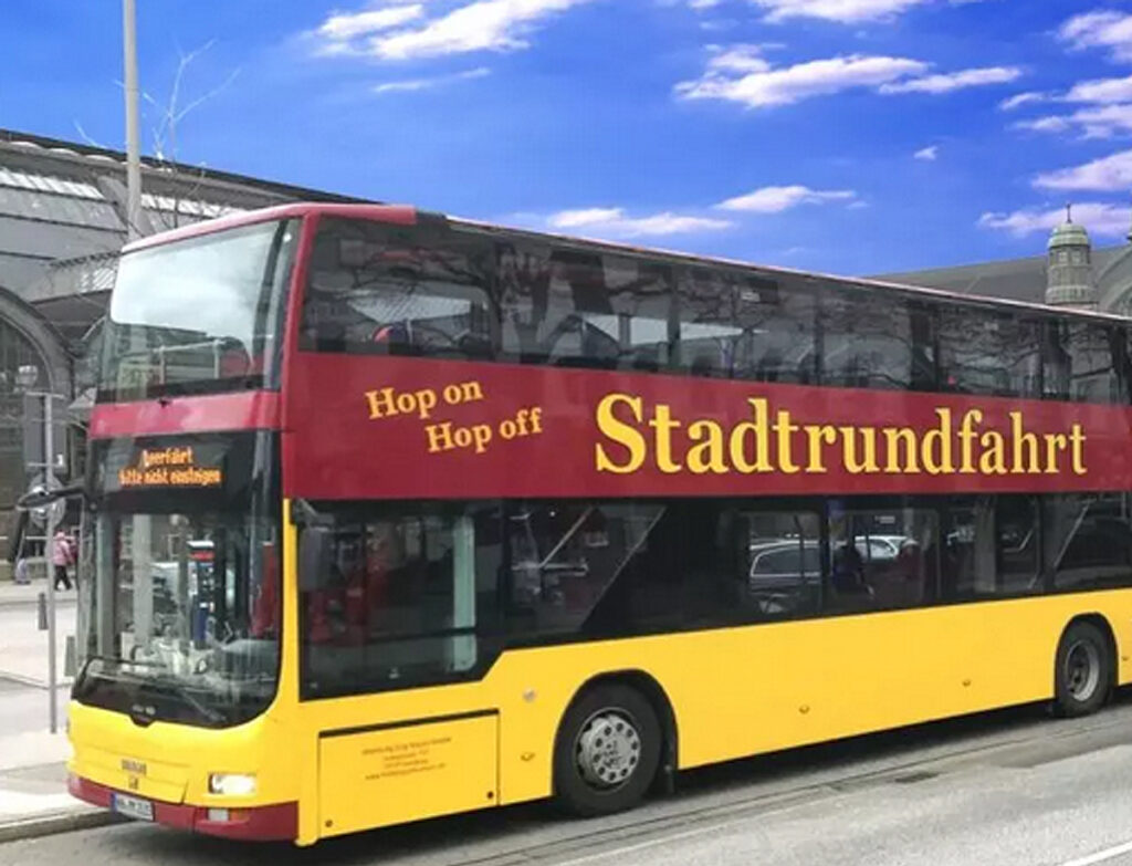 Rot-Gelber Doppeldecker an Haltestelle