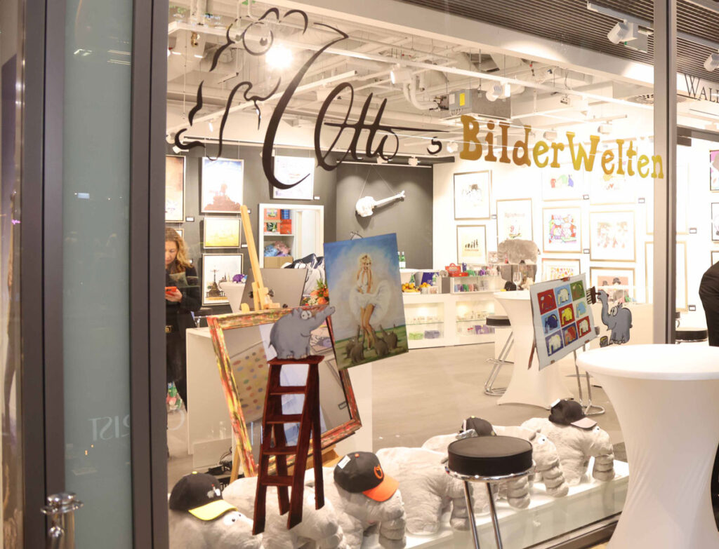 Blick ins Schaufenster der Walentowski Galerien Ottos Bilderwelten mit Gemälden von Otto und Ottifanten-Plüschtieren